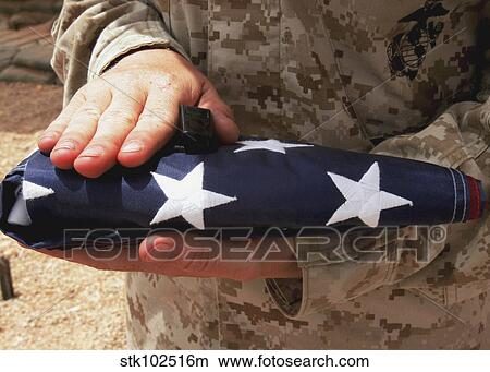 A soldier holds the United States flag. View Large Photo Image Picture - A soldier holds the United States flag.. Fotosearch