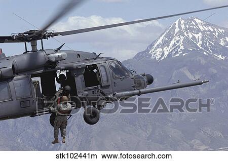A soldier is lifted on board an Air Force HH-60 Pave Hawk. View Large Photo Image Picture - A soldier is lifted on board an Air Force HH-60 Pave Hawk.. Fotosearch