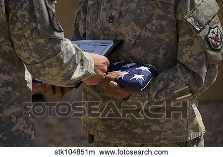 A soldier is presented the American Flag and certificate during a ceremony. View Large Photo Image Picture - A soldier is presented the American Flag and certificate during a ceremony.. Fotosearch