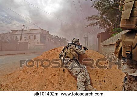 A soldier lays down a vicious barrage of gun fire on insurgent positions. View Large Photo Image Picture - A soldier lays down a vicious barrage of gun fire on insurgent positions.. Fotosearch