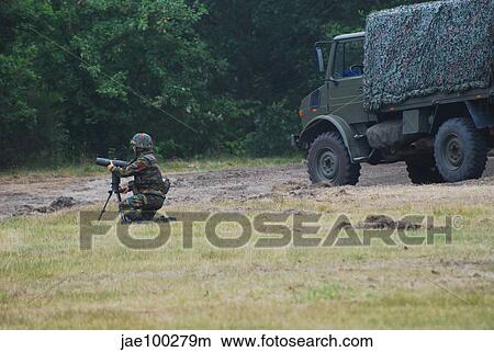 A soldier of the Belgian artillery unit sets up a device to guide howitzer units. View Large Photo Image Picture - A soldier of the Belgian artillery unit sets up a device to guide howitzer units.. Fotosearch