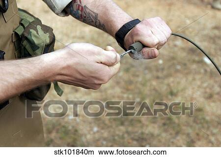 A soldier pulls a detonation cord igniter to start a reaction detonating C-4 explosives. View Large Photo Image Picture - A soldier pulls a detonation cord igniter to start a reaction detonating C-4 explosives.. Fotosearch