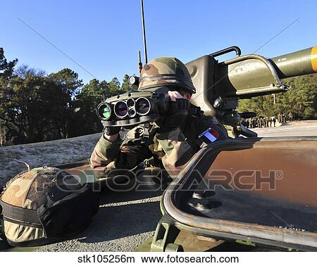 A soldier scans the horizon through a pair of binoculars. View Large Photo Image Picture - A soldier scans the horizon through a pair of binoculars.. Fotosearch