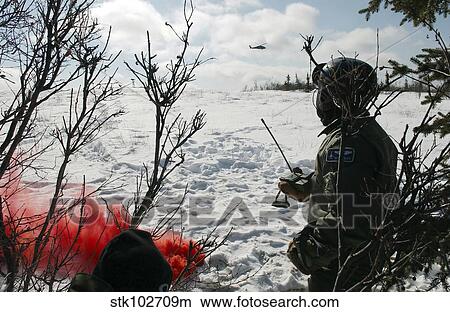 A soldier uses red smoke to signal the nearby HH-60 Pave Hawk helicopter. View Large Photo Image Picture - A soldier uses red smoke to signal the nearby HH-60 Pave Hawk helicopter.. Fotosearch