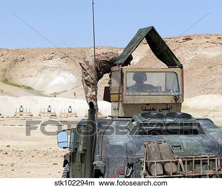 Picture - A soldiier instructs an Iraqi army soldier as he fires a PKC machine gun.. Fotosearch
