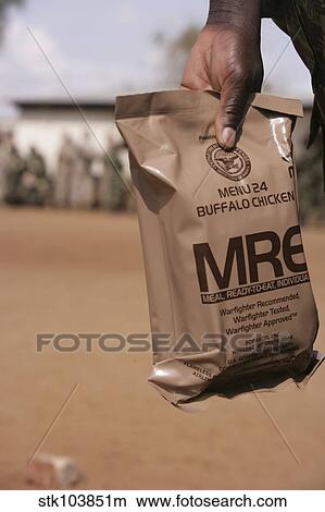 Picture - A solider with the Armed Forces for the Defense of Mozambique holds a buffalo chicken Meal Ready to Eat.. Fotosearch