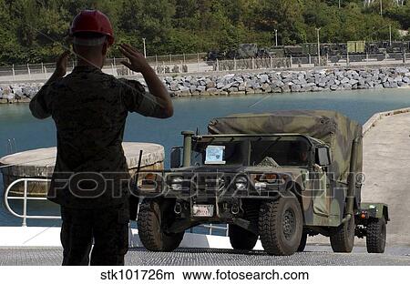 A specialist directs a humvee aboard the high-speed vessel Westpac Expressat Kin Red Port. View Large Photo Image Picture - A specialist directs a humvee aboard the high-speed vessel Westpac Expressat Kin Red Port.. Fotosearch
