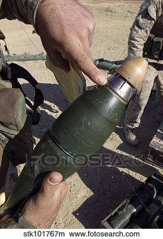 A squad leader points to a delay setting on an 81mm mortar round. View Large Photo Image Picture - A squad leader points to a delay setting on an 81mm mortar round.. Fotosearch