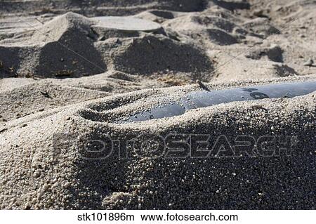 A static display of an ordnance shell and a mine lay half-buried in the sand. View Large Photo Image Picture - A static display of an ordnance shell and a mine lay half-buried in the sand.. Fotosearch