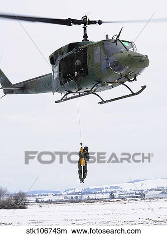 A student is hoisted into a UH-1N Iroquois during a training exercise. View Large Photo Image Picture - A student is hoisted into a UH-1N Iroquois during a training exercise.. Fotosearch