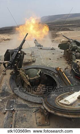 Picture - A tank crewman braces himself after firing a 120mm round from a M1A1 Abrams battle tank.. Fotosearch