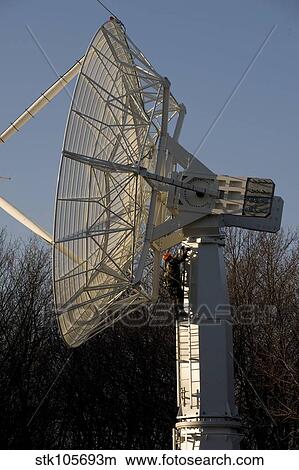 A technician climbs up a large radio telescope antenna. View Large Photo Image Picture - A technician climbs up a large radio telescope antenna.. Fotosearch
