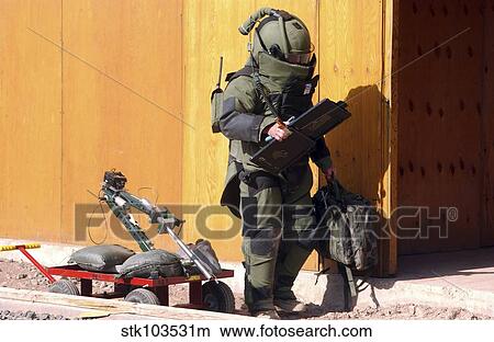 Picture - A technician from a Navy Explosive Ordnance Disposal Mobile Unit holding equipment.. Fotosearch