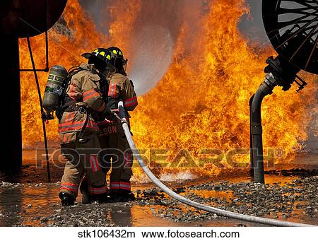 A two-man team battles a blaze at the front of a mock aircraft. View Large Photo Image Picture - A two-man team battles a blaze at the front of a mock aircraft.. Fotosearch