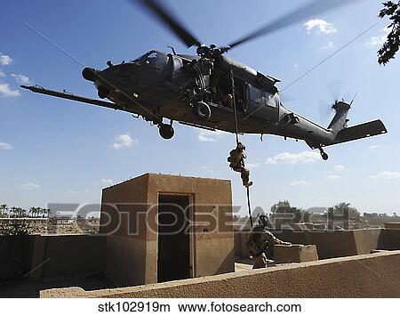 A U. S. Air Force Pararescuemen fast ropes from an HH-60 Pavehawk helicopter. View Large Photo Image Picture - A U. S. Air Force Pararescuemen fast ropes from an HH-60 Pavehawk helicopter.. Fotosearch