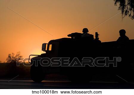 A U. S. Army Humvee with soldiers in the back at sunset. View Large Photo Image Picture - A U. S. Army Humvee with soldiers in the back at sunset.. Fotosearch