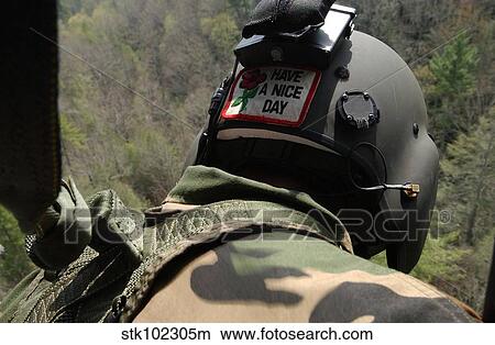 A U. S. Army National Guardsman looks out a UH-60 Black Hawk. View Large Photo Image Picture - A U. S. Army National Guardsman looks out a UH-60 Black Hawk.. Fotosearch