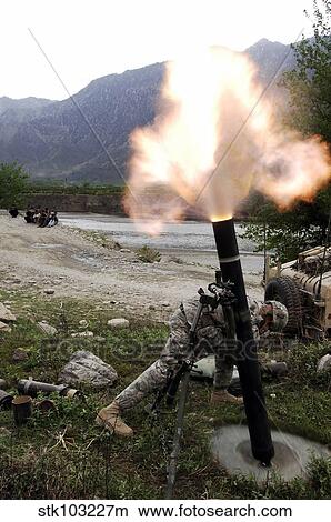 A U. S. Army soldier ducking away from the blast of a 120-mm mortar in Afghanistan. View Large Photo Image Picture - A U. S. Army soldier ducking away from the blast of a 120-mm mortar in Afghanistan. . Fotosearch