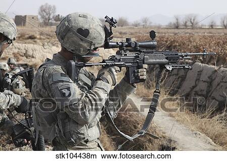 A U. S. Army soldier looks through the scope of his M-14 sniper rifle. View Large Photo Image Picture - A U. S. Army soldier looks through the scope of his M-14 sniper rifle.. Fotosearch