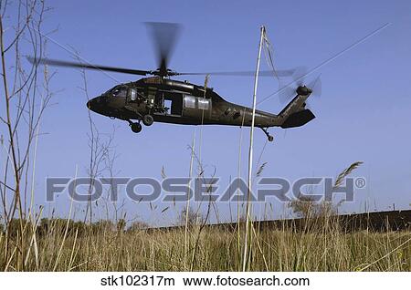 A U. S. Army UH-60 Black Hawk helicopter prepares to pick up soldiers. View Large Photo Image Picture - A U. S. Army UH-60 Black Hawk helicopter prepares to pick up soldiers.. Fotosearch