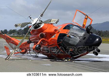 Picture - A U. S. Coast Guard MH-65 Dolphin helicopter lays on its side after it crashed at the Arcata Airport during a training mission.. Fotosearch