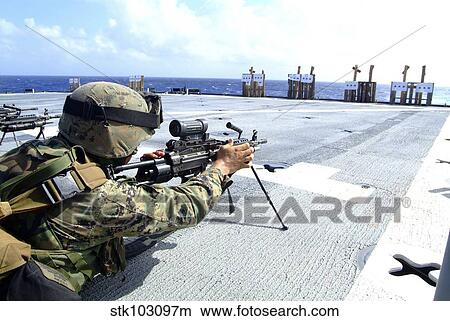 A U. S. Marine adjusting his weapon on the flight deck of USS Harpers Ferry. View Large Photo Image Picture - A U. S. Marine adjusting his weapon on the flight deck of USS Harpers Ferry.. Fotosearch
