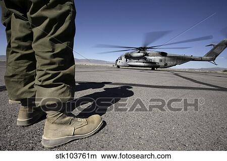 A U. S. Marine Corps airframe mechanic watches a CH-53E Super Stallion helicopter take off. View Large Photo Image Picture - A U. S. Marine Corps airframe mechanic watches a CH-53E Super Stallion helicopter take off.. Fotosearch