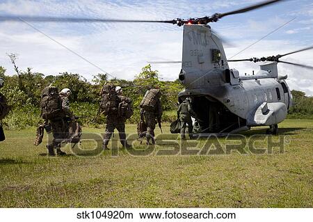 Picture - A U. S. Marine Corps CH-46E Sea Knight embarks Marines for transportation.. Fotosearch