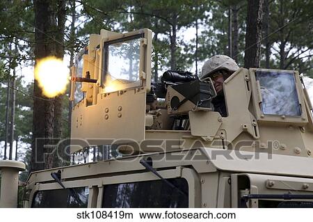 A U. S. Marine fires a M-240B machine gun atop a humvee. View Large Photo Image Picture - A U. S. Marine fires a M-240B machine gun atop a humvee.. Fotosearch