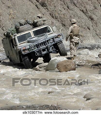 A U. S. Marine guiding the driver of a Humvee through a river in Khowst Province of Afghanistan. View Large Photo Image Picture - A U. S. Marine guiding the driver of a Humvee through a river in Khowst Province of Afghanistan.. Fotosearch