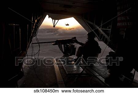 A U. S. Marine provides aerial security from a CH-53E Super Stallion. View Large Photo Image Picture - A U. S. Marine provides aerial security from a CH-53E Super Stallion.. Fotosearch
