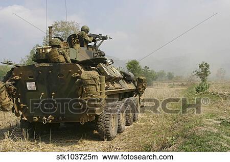 Picture - A U. S. Marine uses an M-240B machine gun from the gun turret of a light armored vehicle.. Fotosearch
