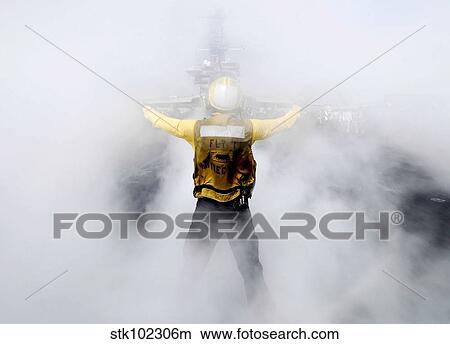 A U. S. Navy flight deck director directs an EA-6B Prowler onto a steam-powered catapult. View Large Photo Image Picture - A U. S. Navy flight deck director directs an EA-6B Prowler onto a steam-powered catapult.. Fotosearch