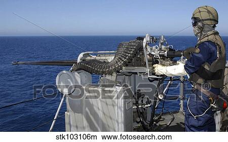 Picture - A U. S. Navy Gunner's Mate firing a. 50-caliber machine gun during weapons training aboard USS Boxer.. Fotosearch