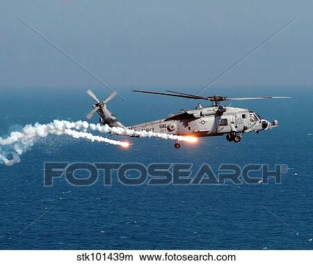 Picture - A U. S. Navy HH-60H Seahawk Helicopter dispenses flares and chaff.. Fotosearch