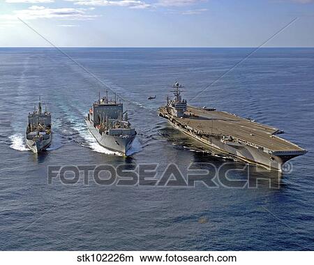 A U. S. Navy MH-60S Knighthawk helicopter conducts vertical replenishment drills. View Large Photo Image Picture - A U. S. Navy MH-60S Knighthawk helicopter conducts vertical replenishment drills.. Fotosearch