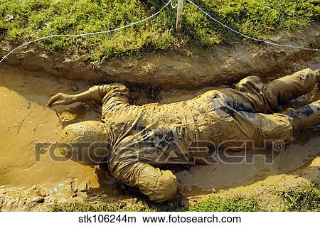 A U. S. Navy midshipman crawls through a foxhole. View Large Photo Image Picture - A U. S. Navy midshipman crawls through a foxhole.. Fotosearch