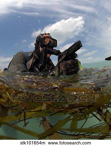 A U. S. Navy SEAL surfaces with his weapon drawn. View Large Photo Image Picture - A U. S. Navy SEAL surfaces with his weapon drawn.. Fotosearch