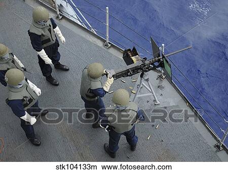 Picture - A U. S. Sailor fires a. 50-caliber M2HB machine gun aboard USS Frank Cable.. Fotosearch