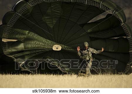 A U. S. soldier collapses his parachute after a static line jump. View Large Photo Image Picture - A U. S. soldier collapses his parachute after a static line jump.. Fotosearch