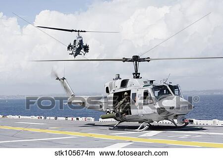 A UH-1N Huey and an AH-1W Super Cobra land on flight deck of USS Essex. View Large Photo Image Picture - A UH-1N Huey and an AH-1W Super Cobra land on flight deck of USS Essex.. Fotosearch