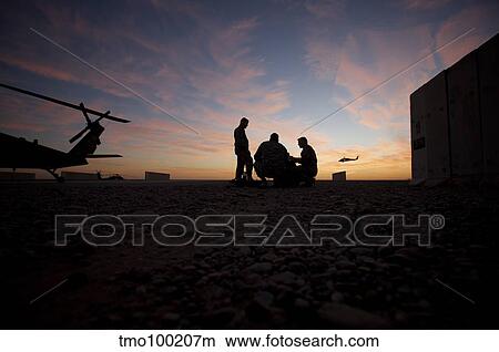 A UH-60 Black Hawk crew carry out a mission brief at sunset. View Large Photo Image Picture - A UH-60 Black Hawk crew carry out a mission brief at sunset.. Fotosearch