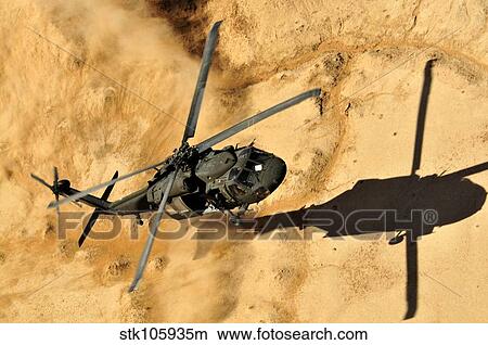 A UH-60 Black Hawk helicopter comes in for a dust landing. View Large Photo Image Picture - A UH-60 Black Hawk helicopter comes in for a dust landing.. Fotosearch