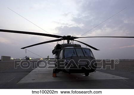 A UH-60 Black Hawk helicopter on the flight line at dusk in Tikrit, Iraq. View Large Photo Image Picture - A UH-60 Black Hawk helicopter on the flight line at dusk in Tikrit, Iraq.. Fotosearch