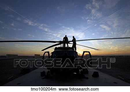 A UH-60 Black Hawk helicopter on the flight line at sunset. View Large Photo Image Picture - A UH-60 Black Hawk helicopter on the flight line at sunset.. Fotosearch