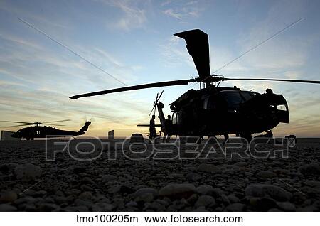 A UH-60 Black Hawk helicopter on the flight line at sunset. View Large Photo Image Picture - A UH-60 Black Hawk helicopter on the flight line at sunset.. Fotosearch
