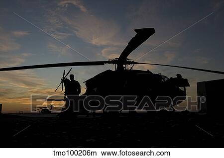 A UH-60 Black Hawk helicopter on the flight line at sunset. View Large Photo Image Picture - A UH-60 Black Hawk helicopter on the flight line at sunset.. Fotosearch
