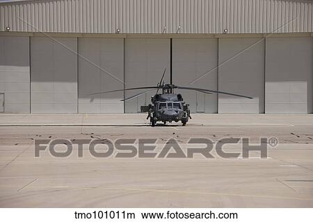 A UH-60 Black Hawk helicopter parked in front of a hanger. View Large Photo Image Picture - A UH-60 Black Hawk helicopter parked in front of a hanger.. Fotosearch