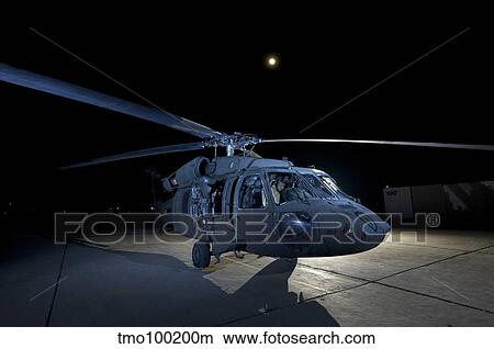 A UH-60 Black Hawk helicopter parked on the flight line under a full moon. View Large Photo Image Picture - A UH-60 Black Hawk helicopter parked on the flight line under a full moon.. Fotosearch