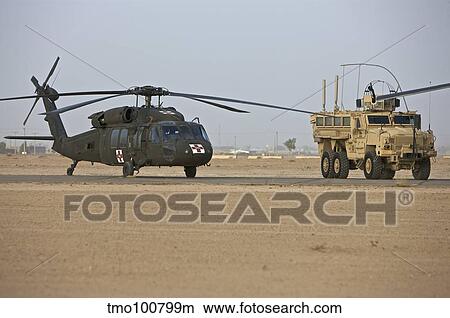 A UH-60 Black Hawk medevac helicopter and a RG-33 MRAP. View Large Photo Image Picture - A UH-60 Black Hawk medevac helicopter and a RG-33 MRAP.. Fotosearch